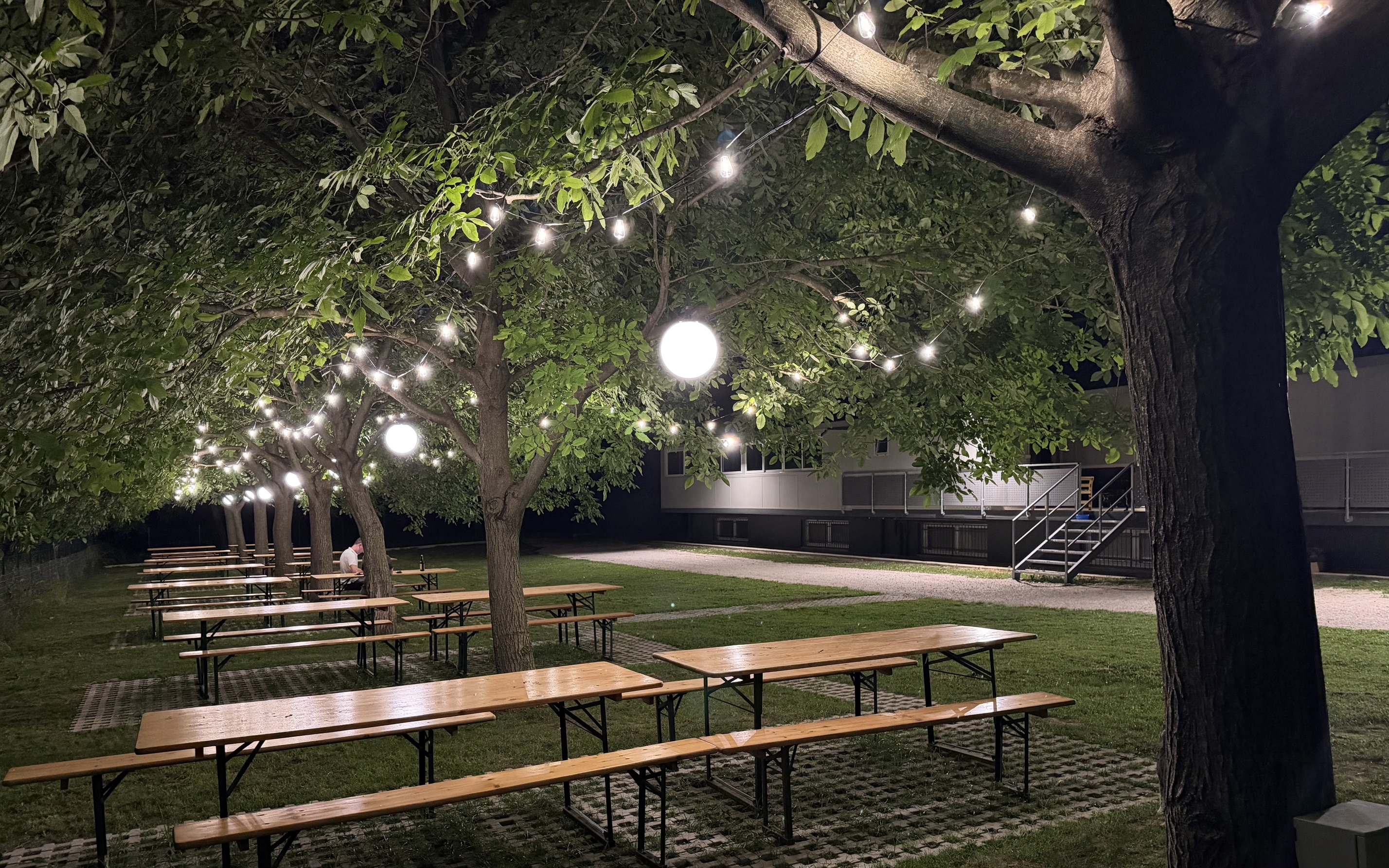 Camarin RistoGarden — allestimento serale con tavoli conviviali e luci tra gli alberi